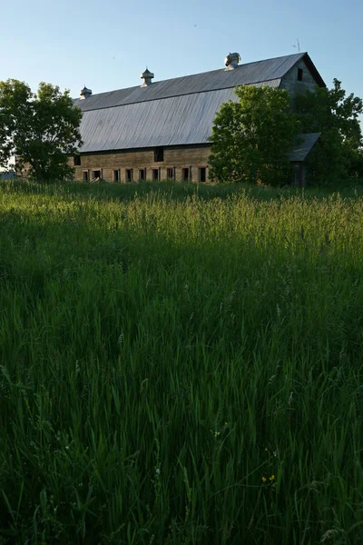 Travnaté hřiště s staré stodoly na pozadí — Stock fotografie