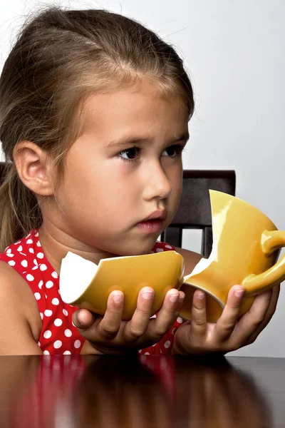 Frustrated little girl with a broken cup — Stock Photo, Image