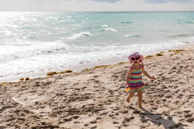 Şapka ve güneş gözlüğü gülüyor ve kaçak mutlu küçük kızla 