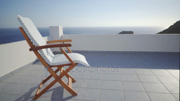 Empty Deck Chair On A Breezy Terrace Of A Holiday Resort In Summer By The Sea In Greece. — Stock Footage Empty Deck Chair Breezy Terrace Holiday Resort Summer Sea Greece Stock Footage