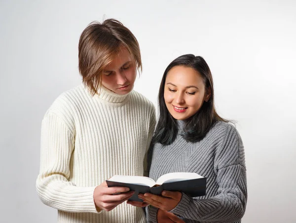 Ung man och kvinna läser en bok tillsammans — Stockfoto