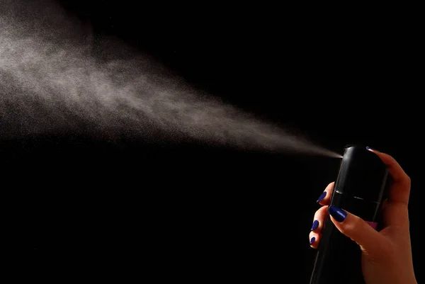 Der Dispergierstrahl aus einer Spraydose in weiblicher Hand — Stockfoto