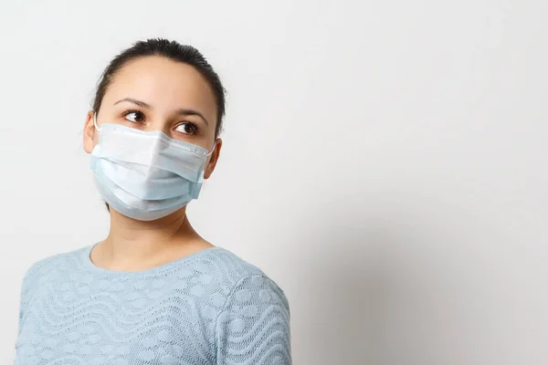 Studioporträt einer jungen Frau mit Gesichtsmaske, die in die Kamera blickt, aus nächster Nähe, isoliert auf grauem Hintergrund. Grippeepidemie, Stauballergie, Schutz vor Viren — Stockfoto