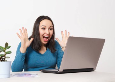 Dizüstü bilgisayarında oturan mutlu, mutlu bir kadın. Beyaza. Başarı konsepti, serbest çalışma, uzaktan kazanç, bilgisayar teknolojisi, piyango, kazanma.