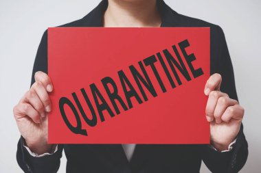 Ceketli bir iş kadını üzerinde karantina yazan kırmızı bir levha tutuyor. Ekonominin yeni bir Coronavirus covid-19 2019-ncov 'a tepkisi.