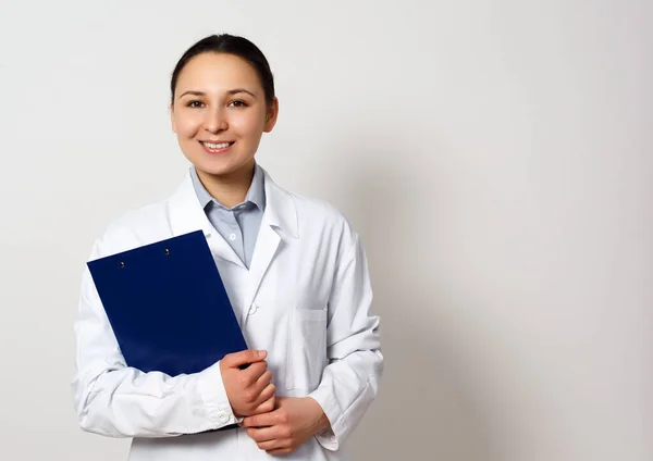 女性医療従事者の肖像画です 若いです医師とともにクリップボード上の白い背景 — ストック写真