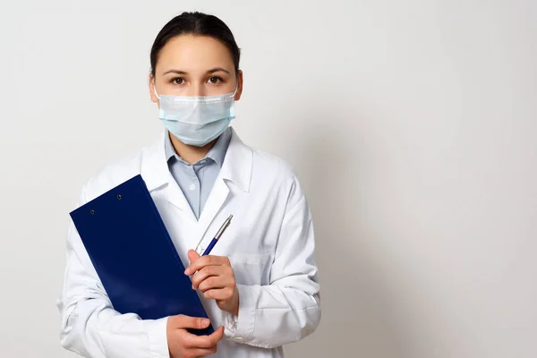 Portrait Female Doctor Protective Mask Clipboard Pen Her Hands Making — Stock Photo, Image