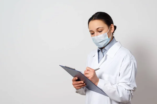 Portrait Female Doctor Protective Mask Clipboard Pen Her Hands Making — Stock Photo, Image