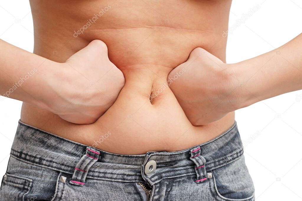 the girl presses the fat on her stomach with two fists inside. front view, white background