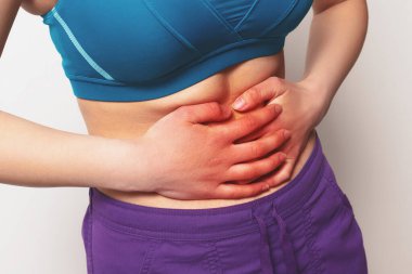 Beyaz arka planda karın ağrısı çeken bir kadın..