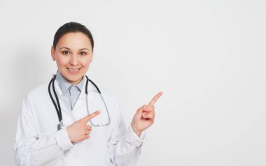 Bir kadın doktor iki eliyle fotokopi için sağdaki beyaz arkaplanı işaret eder..