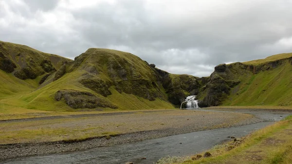 Coberto por montanhas de musgo e uma cachoeira do castelo na Islândia — Fotografia de Stock