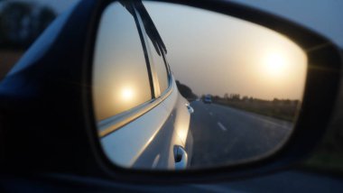 Güneş ve yolun araba aynadaki ışığı.