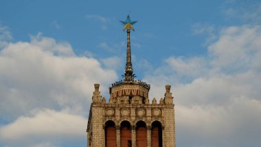 Sarı ve mavi gökyüzü arka planı boyalı olduğu yıldız bir sivri olan bir ev.