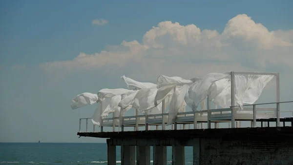 Rüzgar dalgaları Yatak perdeleri mavi gökyüzü arka plan üzerinde beach oteller.