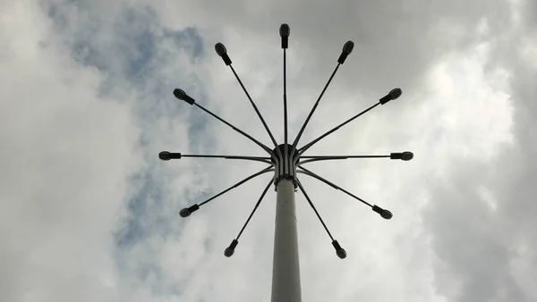 Een Zuil Met Een Paar Lantaarns Tegen Een Bewolkte Hemel — Stockfoto