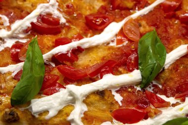 Domatesli pizza, peynir ve fesleğen.