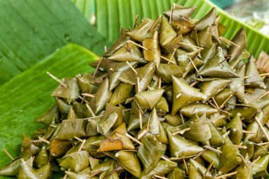 Khao Tom, geleneksel Thai ve laos tatlıları muz yapraklarına sarılmış baharatlı yapışkan pirinçten oluşur.