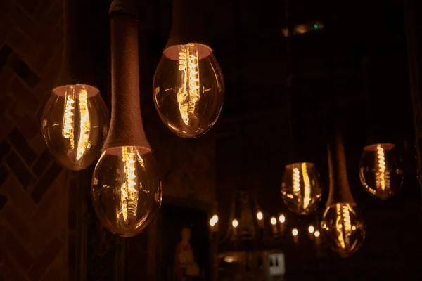 Decorative antique  style light bulbs on the background of a mirror that reflects the light bulbs.