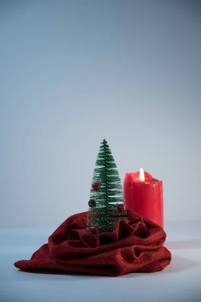 袋からクリスマスツリーが見える。おもちゃのクリスマスツリー。背景にある赤いろうそくは. — ストック写真