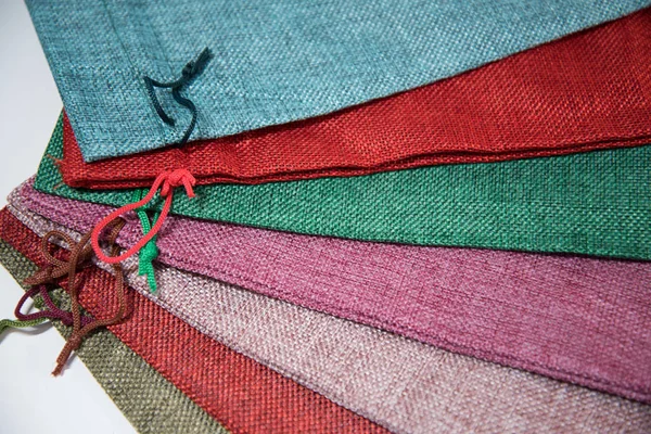 Sacchetti di tessuto per l'imballaggio di regali di diversi colori, su sfondo bianco . — Foto Stock