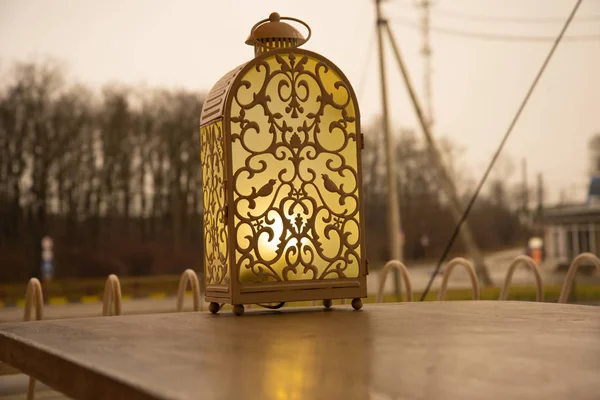 Una lámpara de cuento de hadas, una linterna, está sobre la mesa de un café callejero. Confort y cálida luz amarilla . —  Fotos de Stock