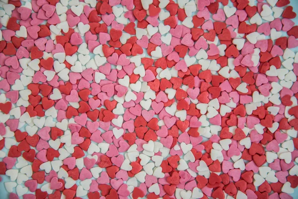 Tło małych wielobarwnych serc. Serca są białe, czerwone i różowe. — Zdjęcie stockowe
