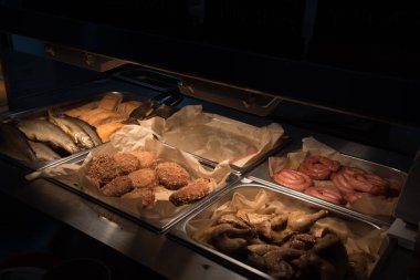 Self-service canteen. Sausages, fish, chicken, and cutlets are laid out in large metal containers