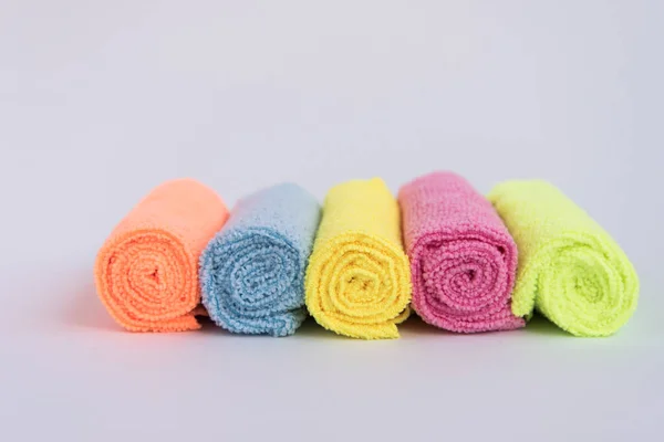 Paños de microfibra multicolores, doblados en rodillos. Las telas están dispuestas en fila . —  Fotos de Stock