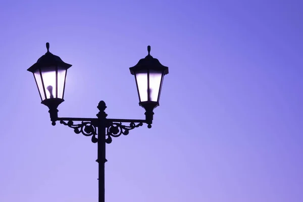 Paesaggio urbano. Lampada da strada con una lampada in stile classico contro un cielo viola. Bellissima cartolina . — Foto Stock