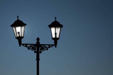 Şehir manzarası. Mor gökyüzüne karşı klasik tarzda bir lamba ile sokak lambası. Güzel kartpostal.