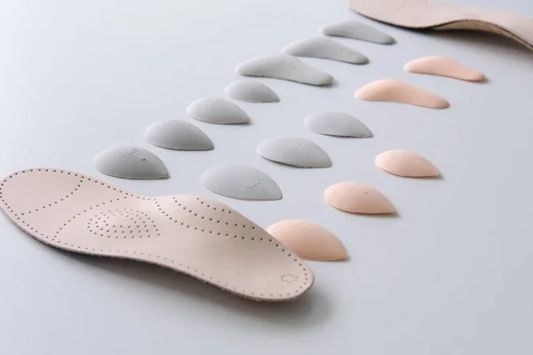 Le processus de fabrication de semelles orthopédiques individuelles pour les personnes atteintes de maladies des pieds, pieds plats. Gros plan sur la semelle intérieure et ses accessoires . — Photo