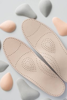 Parçalarla çevrili bir çift deri ortopedik taban. Farklı şekil ve boyutlardaki çapraz kemeri boşaltmak için pelotlar. Seçenek.