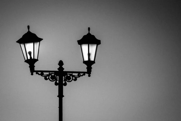 Straatlamp met lampen in een klassieke stijl tegen een donkerblauwe lucht. Donkere avond of nacht. — Stockfoto