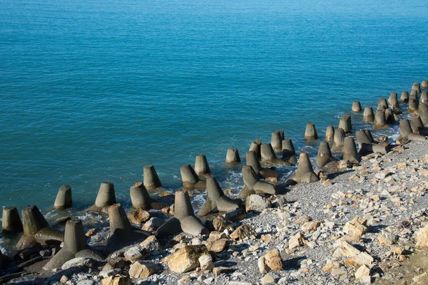 Tetrapod-Buhnen an der Küste. Betonbuhnen von Tetrapoden liegen entlang der gesamten Küste. — Stockfoto