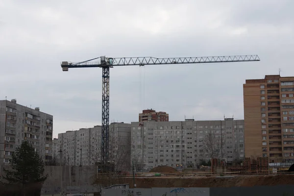 Vista di una gru a torre in un cantiere tra edifici a più piani. Tecnologia — Foto Stock