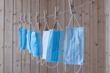 Tek kullanımlık tıbbi maskeler çamaşır ipine asılı. Kavram. Tekrar kullan. Eksik