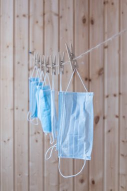 Tek kullanımlık tıbbi maskeler çamaşır ipine asılı. Kavram. Tekrar kullan. Eksik ve yetersiz.
