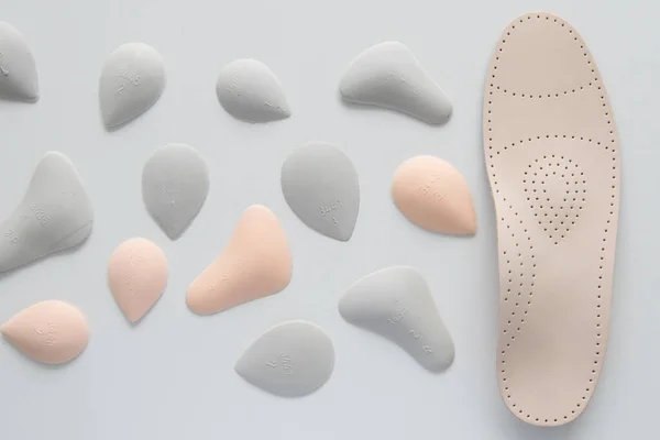 Orthopedic insoles on a white background. Treatment and prevention of flat feet and foot diseases. Foot care, foot comfort. Wear comfortable shoes. Medical insoles.