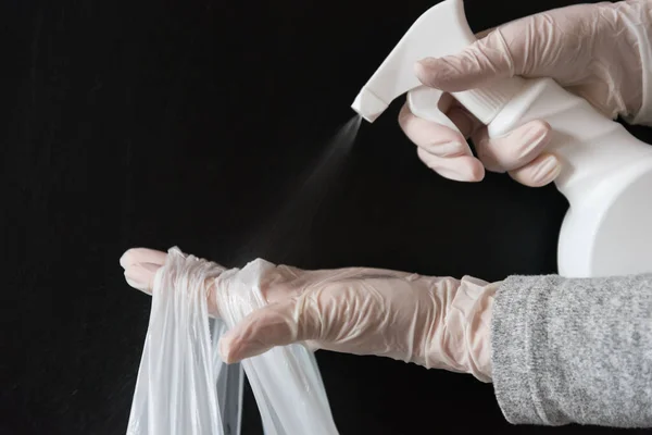 Hands of a person disinfecting a delivery bag. Safe delivery.
