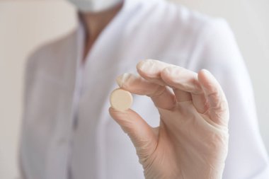Eldivenli bir doktor elinde bir tablet tutuyor. İşaret yaklaşıyor. Bakım konsepti