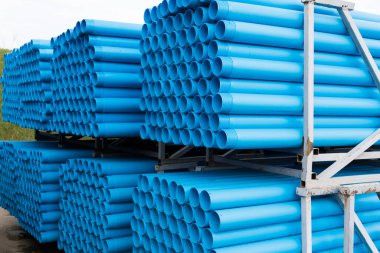 Mavi plastik borular özel metal raflara döşenmiş. Plastik boruların üretimi ve pazarlanması