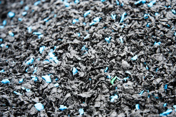 Particles of crushed plastic are black in color. Plastic before melting. The concept of caring for the environment.