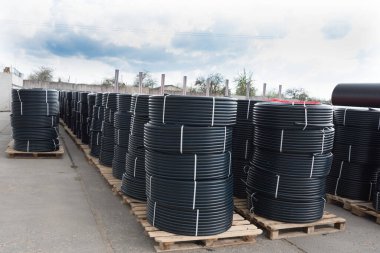 Bir sürü rulo plastik boru. Stok, yumurtlama hazırlığı. Siyah boruların ruloları