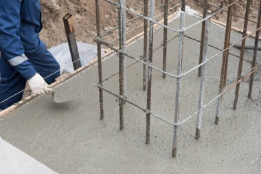 Taze betonu sıkıştırma ve düzleştirme süreci. Formalitelere beton dökülüyor..