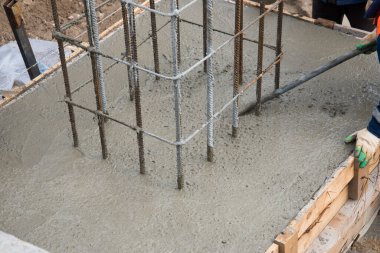 Taze betonu sıkıştırma ve düzleştirme süreci. Formalitelere beton dökülüyor..