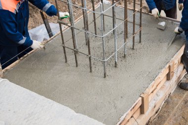Taze betonu sıkıştırma ve düzleştirme süreci. Formalitelere beton dökülüyor..