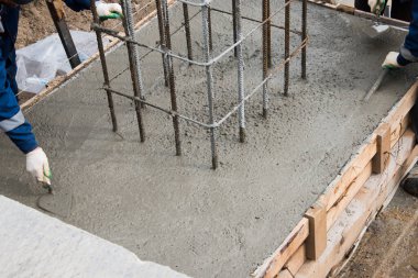 Taze betonu sıkıştırma ve düzleştirme süreci. Formalitelere beton dökülüyor..