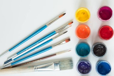 Gulajlı kavanozlar ve farklı boylarda boya fırçaları. Yukarıdan manzara. Arka plan, doku. Yaratıcılık için alan kavramı