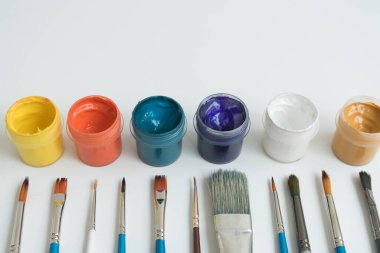 Gulajlı kavanozlar ve farklı boylarda boya fırçaları. Yukarıdan manzara. Arka plan, doku. Yaratıcılık için alan kavramı